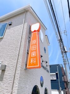 オレンジ色の看板です。先にオレンジに目が行って上にある歯に気づいてもらえるかな？